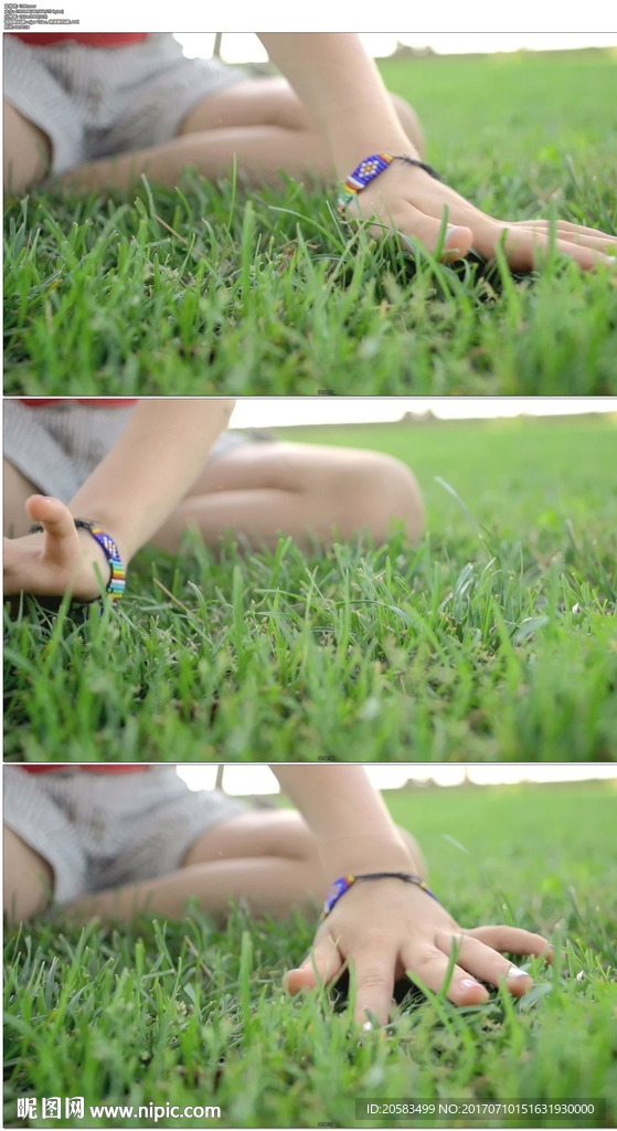 一个小女孩的手抚摸青草