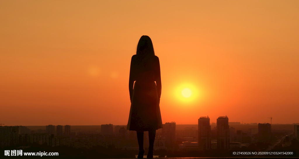 在日落时在屋顶上的女人