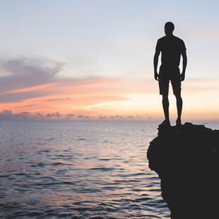 夕阳下大海边男人剪影