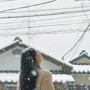女孩站在窗内看雪景