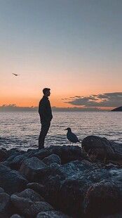 夕阳下大海边男人剪影