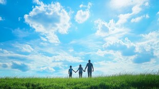 一家人在蓝天下的草地上手牵手