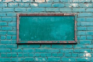 绿色砖墙上的复古黑板