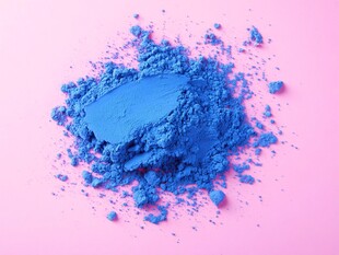 蓝色粉末在粉色背景上的散落