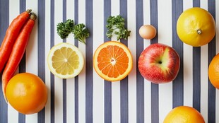 五彩斑斓的水果和蔬菜在条纹桌布上排列