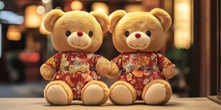两只穿着红色花纹衣服的泰迪熊坐在桌子上