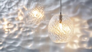 现代简约风格的吊灯与波浪状金属墙的结合