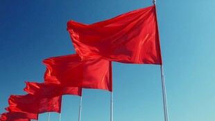 红色警示旗飘扬在蓝天下