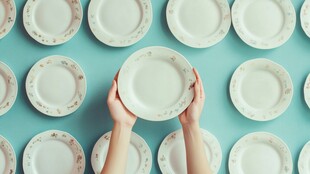 双手捧盘于多彩瓷盘之上