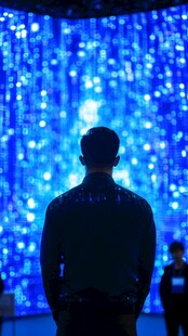 男子凝视梦幻蓝色光影墙