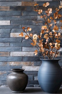 蓝灰花瓶与砖墙前的插花