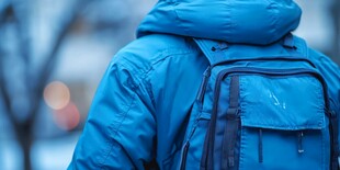 穿蓝外套背背包的行人背影