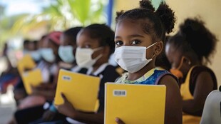 戴口罩的孩子手持黄色本子