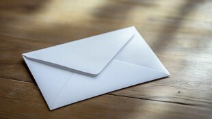 白色信封静置于木质桌面