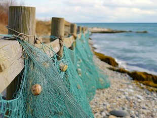 海边木栏挂着的绿色渔网