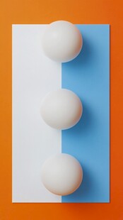 三色背景上的三颗白圆球