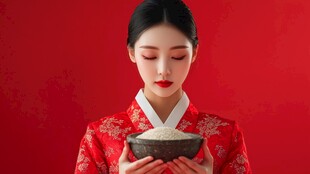 红衣女子捧碗展示白米