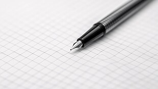 钢笔置于方格纸上特写
