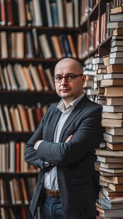 男子立于书墙前显沉稳