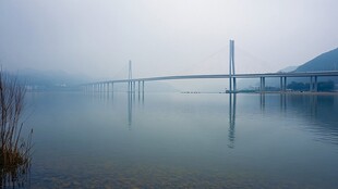 雾中大桥横跨宁静水面