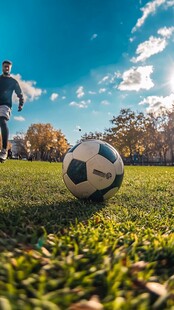 阳光下绿茵场的足球瞬间