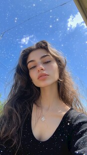 阳光下闭眼的长发时尚女子