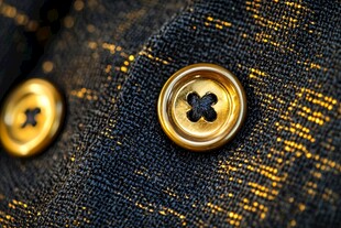 金色纽扣特写于深色织物上