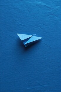 蓝色背景上的简约折纸飞机