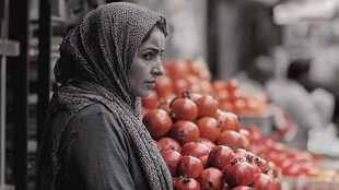 头巾女子于水果摊前静立