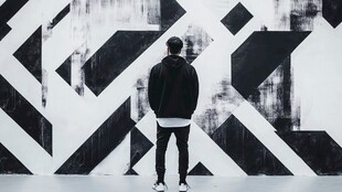 男子凝视几何图案墙面