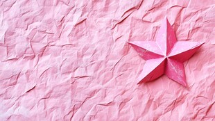 粉色折纸星星于褶皱背景