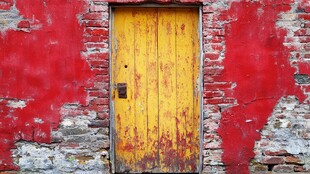 斑驳红墙中的老旧黄木门