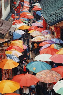 雨中古巷多彩伞下行人忙