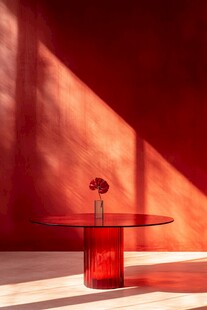 红墙下的简约玻璃圆桌花瓶