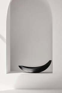 极简白墙下的黑色弧形摆件