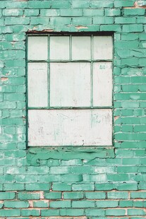 绿色砖墙中的老旧窗户