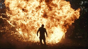 人立于熊熊烈火前身影