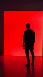 男子立于红墙前的剪影