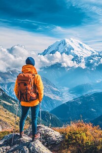 背包客眺望壮丽雪山美景