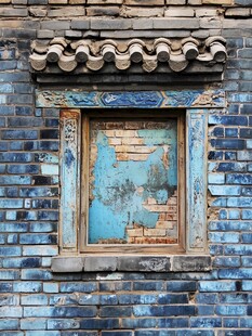 古旧蓝砖墙上的斑驳窗