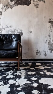 复古风旧墙旁的黑色皮椅