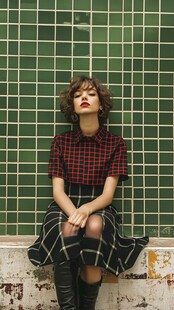 复古风女子倚坐绿瓷砖墙前