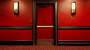 红色墙面间的复古电梯门