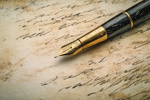 复古钢笔置于手写旧纸上