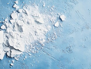 蓝色背景上的白色粉末碎块