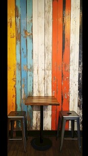 多彩木板墙下的桌椅组合