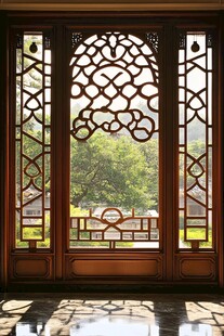 中式雕花窗棂外的绿意