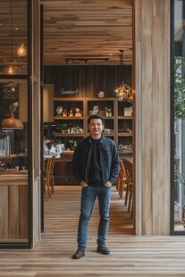 男子立于温馨木质咖啡店门口