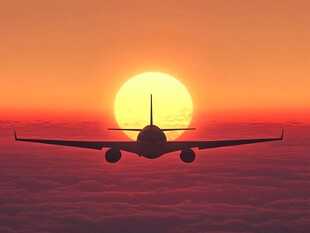 夕阳下飞机翱翔天际