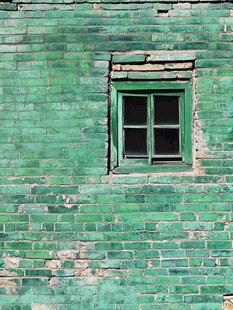 绿砖墙中的老旧窗户